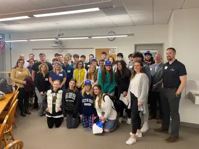 Group of students and volunteers in a classroom